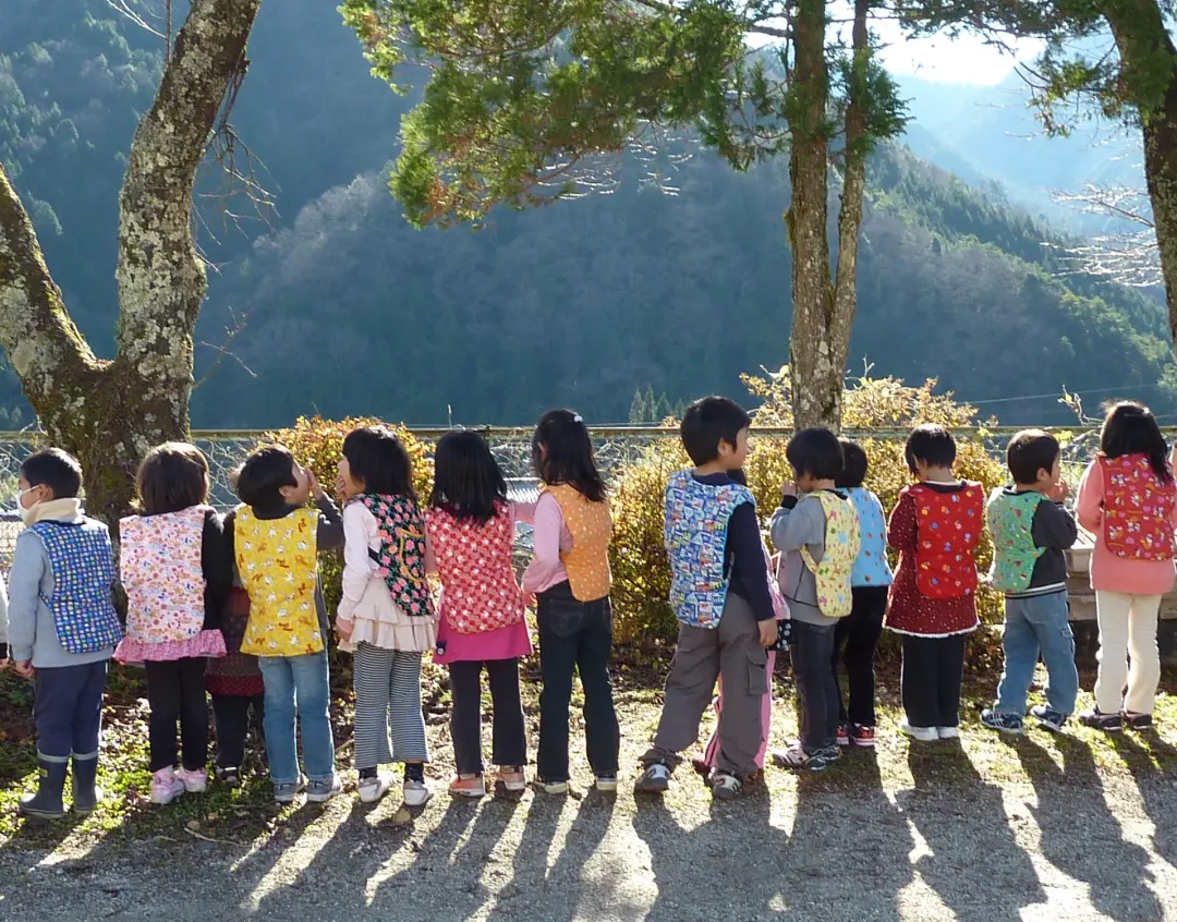 町特産品「南木曽ねこ」を背負う園児たち